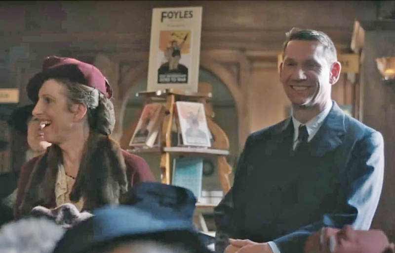 Still from the film showing Mark Seward pretending to laugh in Foyles book shop during war time.
